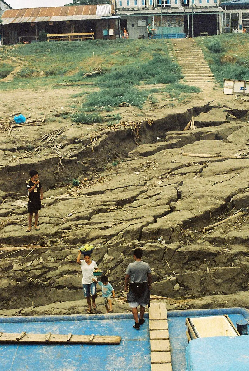 Villagers on the dried mud riverbank at an Amazon boat stop