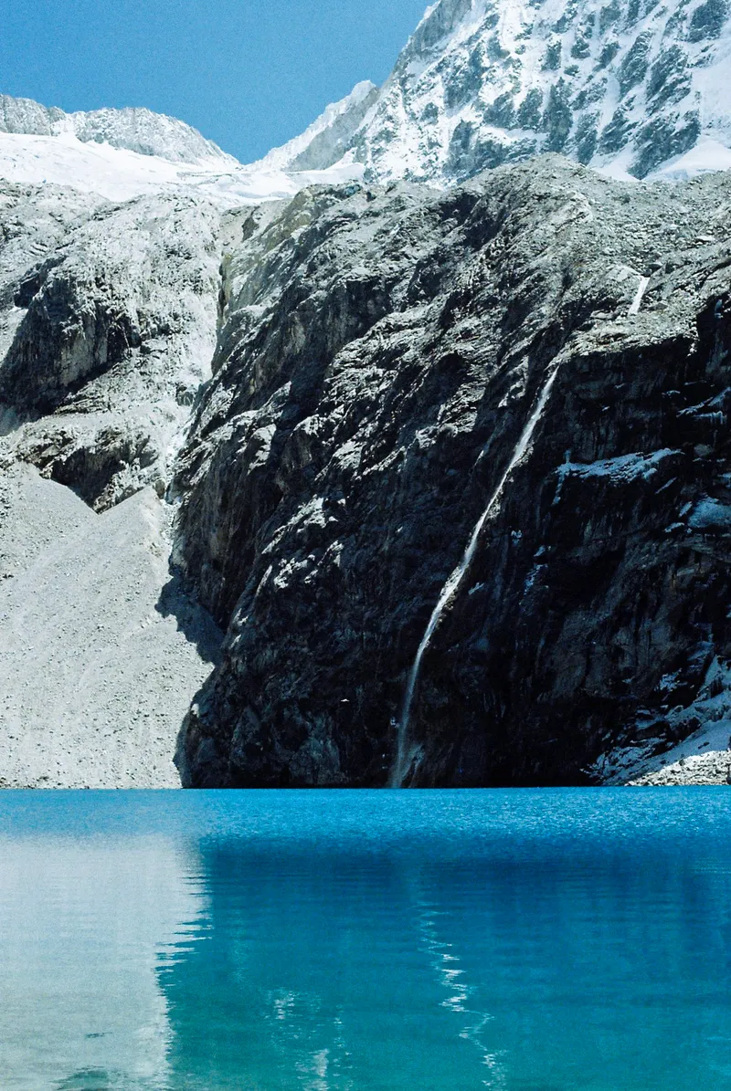 Meltwater falling into the turquoise water of Laguna 69, Peru