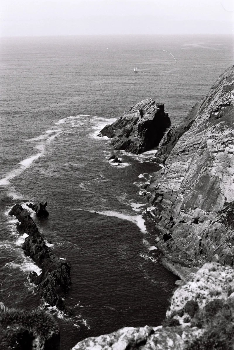 Sailboat passing the cliffs at Three Castle Head, County Cork
