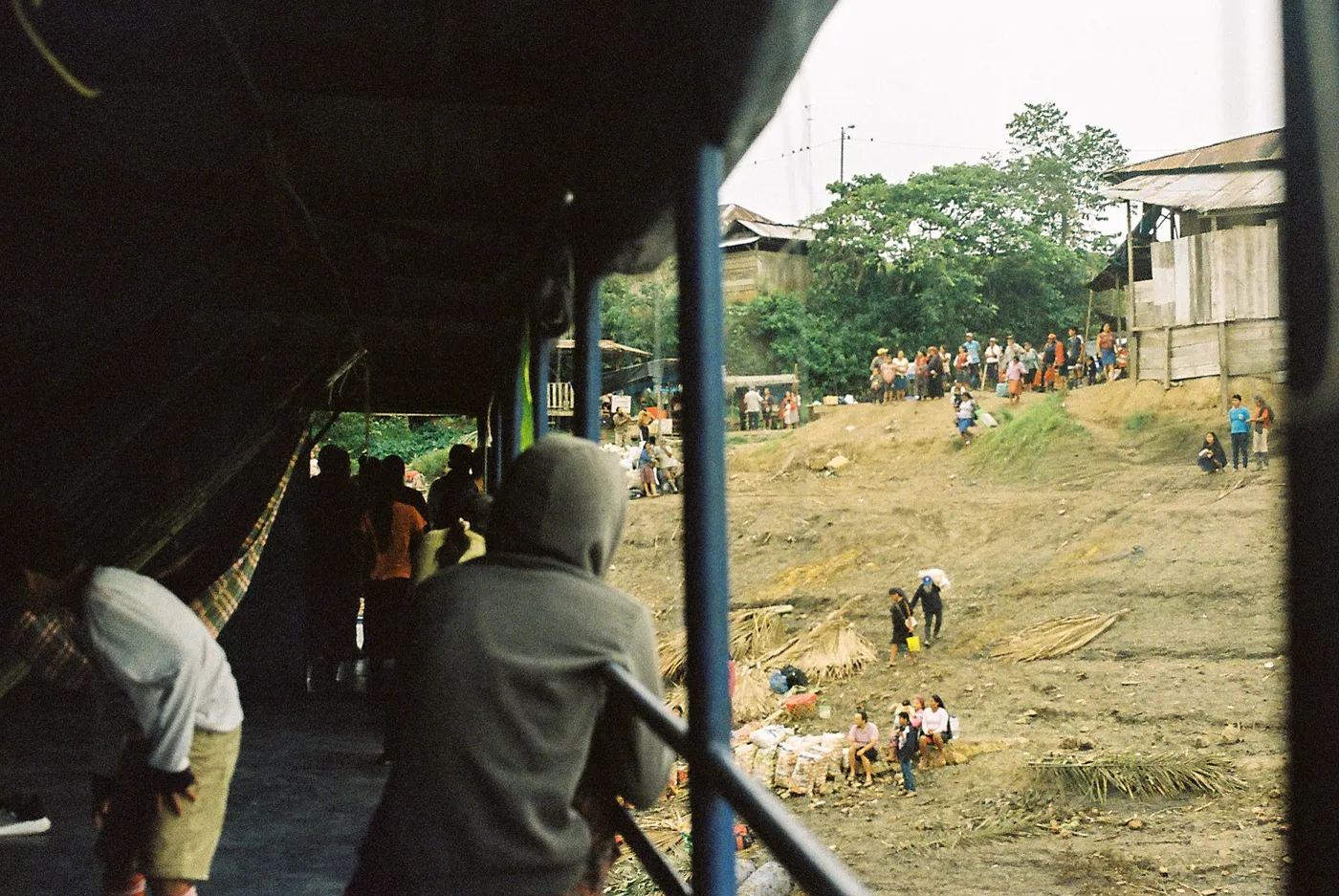 Passengers watching a riverbank stop from an Amazon slow boat
